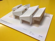 a model of a building on top of a yellow table with the words dao written below it