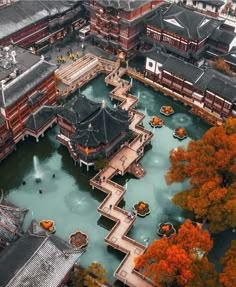 an aerial view of a city with many buildings and trees in the foreground, surrounded by water