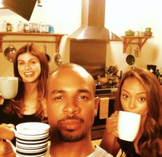 two women and a man drinking coffee in the kitchen