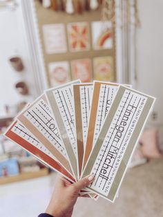 a person holding up four different types of stickers in their hand, with the words on them