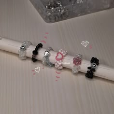 a pencil with several different colored bows on it next to some crystal beads and a diamond