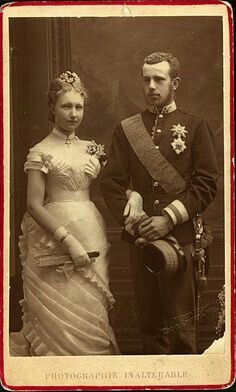 an old photo of a man and woman in formal dress