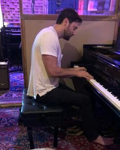 a man sitting at a piano playing it