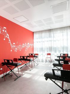 an empty classroom with red walls and musical notes painted on the wall