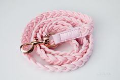 a pink dog leash with gold hardware on a white background for use as a leash