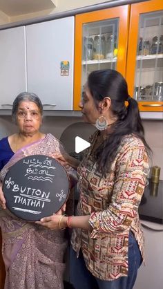 two women standing in a kitchen holding a blackboard that says lotus namhatra