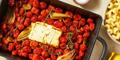 a pan filled with pasta and vegetables next to other foods