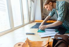 a woman sitting at a table working on something