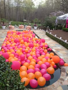 there are many orange and pink balloons on the ground