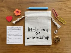 a little bag of friendship on a table next to some buttons and paper clips