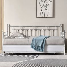 a white daybed sitting on top of a carpeted floor