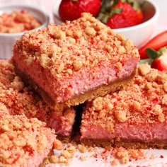 strawberry crumb bars stacked on top of each other with strawberries in the background