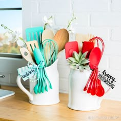 two white mugs filled with kitchen utensils