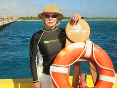 a man in a wet suit and hat standing next to an orange life preserver