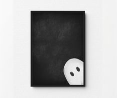 a black and white photo with a ghost mask on it's face in front of a chalkboard