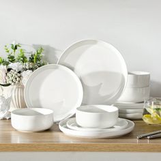 white dishes and cups are arranged on a table