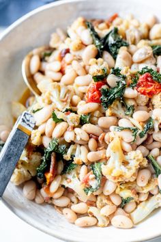 a white bowl filled with beans and vegetables