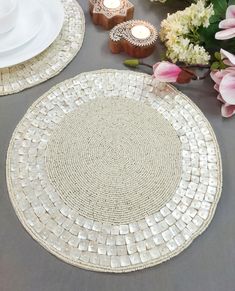 the table is set with white plates and flowers