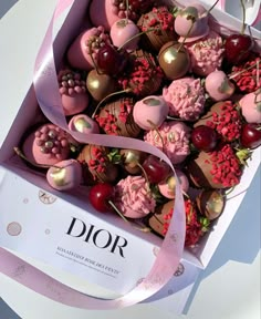 a box filled with lots of different types of chocolate covered candies and cherries