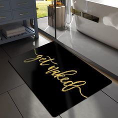 a bath mat that says happy on the floor next to a sink in a bathroom