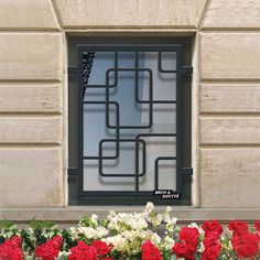 red and white flowers sitting in front of a window with bars on the windowsill