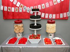 a table topped with lots of food and desserts next to a red flag on the wall