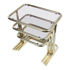 a gold metal and glass side table with two legs on each side, the top is turned upside down