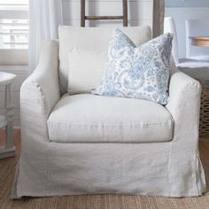 a white chair with blue and white pillows