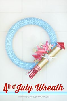 a blue wreath with red, white and gold stars hanging from it's side