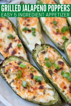 grilled jalapeno peppers with cheese and green onions on a white plate