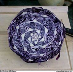 a purple cabbage sitting on top of a cutting board