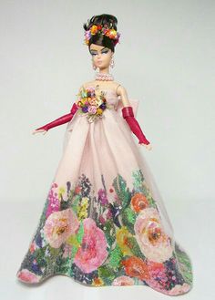 a barbie doll wearing a pink dress with flowers on it's chest and arms