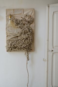 a piece of cloth hanging on the wall with a light bulb attached to it's side