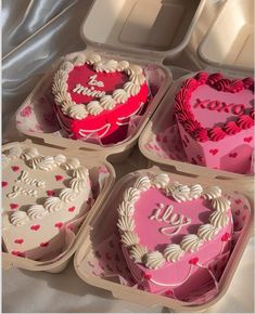 four heart shaped cakes in plastic containers on a table