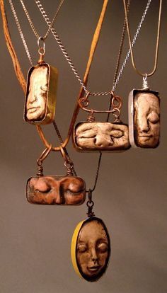 a group of necklaces that have faces on them