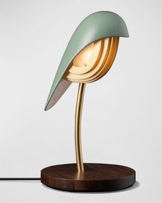 a table lamp that is on top of a wooden base and has a green shade