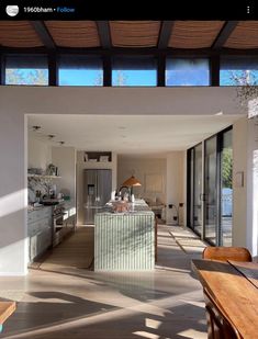 an open kitchen and dining room area with large windows on the side of the house