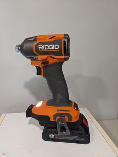 an orange and black cordless drill is on display