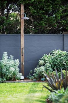 an outdoor shower in the rear garden made from tallwood with a copper rose