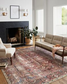 a living room filled with furniture and a rug on top of a hard wood floor