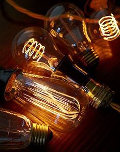 three light bulbs sitting on top of a wooden table