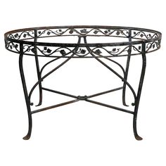 an ornate iron table with glass top