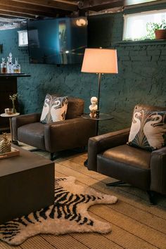 a living room with two brown chairs and a zebra rug