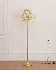 a floor lamp that is on top of a hard wood floor next to a wall