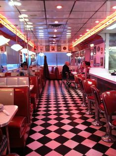 diners are sitting in booths with checkered flooring