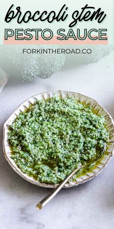 broccoli and pesto sauce in a bowl with spoons on the side