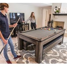 two people are playing pool in the living room