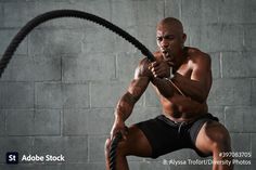 a shirtless man holding a rope in his hands