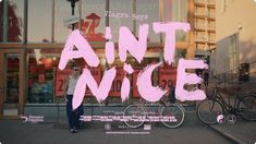 a man standing in front of a store window with the words'anti nice'painted on it