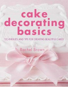 a cake decorated with pink ribbon on top of a wooden block that says cake decorating basics